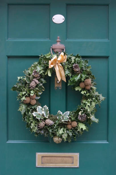 Holly Christmas Wreath Hanging on a Green Door.