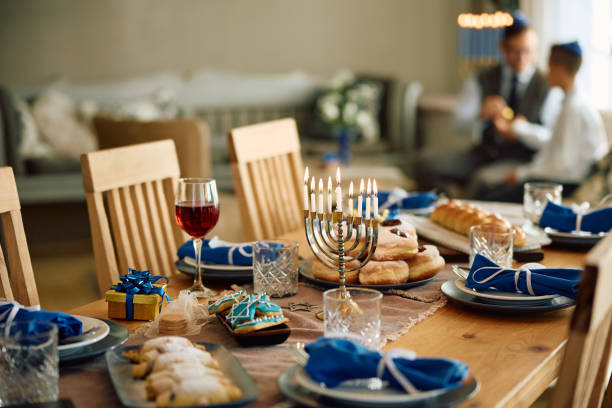 hanukkah dining table setting with father and son in the background. - gelt imagens e fotografias de stock