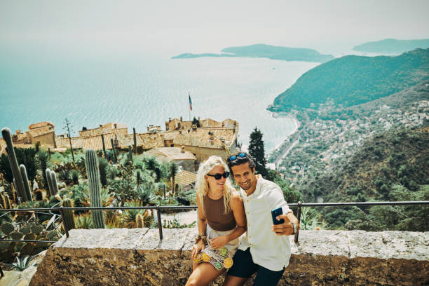 happy millennial couple, exploring the historic village of eze in the south of france, while on vacation. - nice looking imagens e fotografias de stock