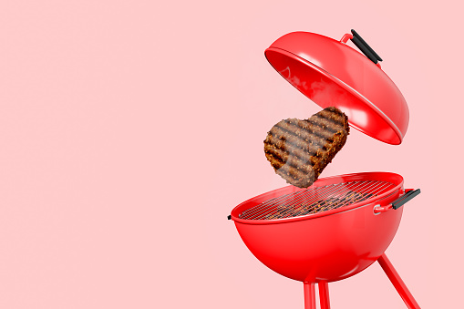 Red barbecue with a heart-shaped burger on an isolated background and space for text. 3d rendering