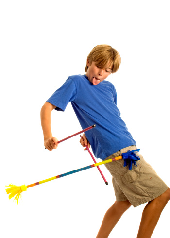 A boy using devil sticks isolated on white.