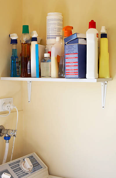 Cleaning products placed on shelf Messy shelf of household cleaning products, over washing machine. three pin plug stock pictures, royalty-free photos & images