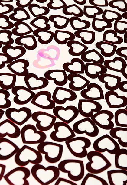 Pink Hearts Canoodling In a Crowd of Dark Two translucent pink hearts canoodle in plain view of the crowd of darker red hearts around them canoodling stock pictures, royalty-free photos & images