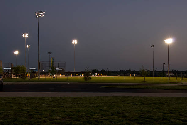 Youth League Baseball Field at Dusk Youth League Baseball Field at Dusk from a distance, with light towers. outfield stock pictures, royalty-free photos & images