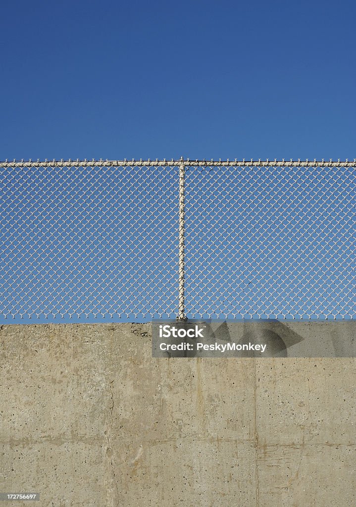Chain LInk Fence and Concrete Wall "Even layers of poured concrete, old chain link, and pure blue sky" Palestinian Stock Photo