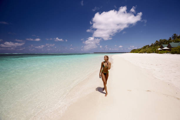 istock Young smiling woman taking a summer walk on the beach. 1727575739