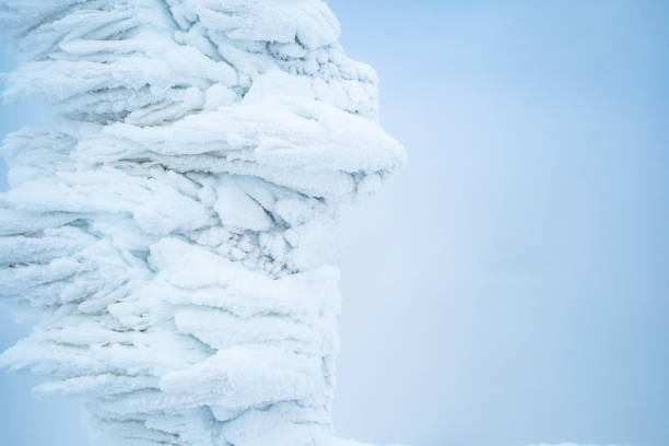 Icy pole covered with large amount of ice on light blue background