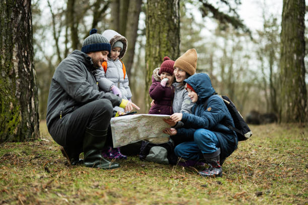 istock Family and kids with map in the forest. 1727584445