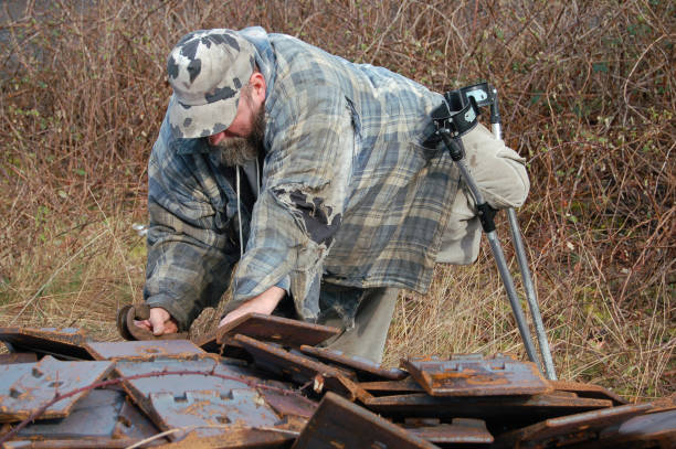 Handicapped man scrounges through a metal heap looking for items of value.PLEASE SEE MY OTHER HOMELESS PHOTOS