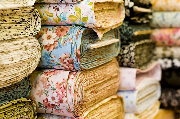 Soft Fabrics in a Shop Stacks of material, ready for a designer.  Shallow depth of field. fabric shop stock pictures, royalty-free photos & images