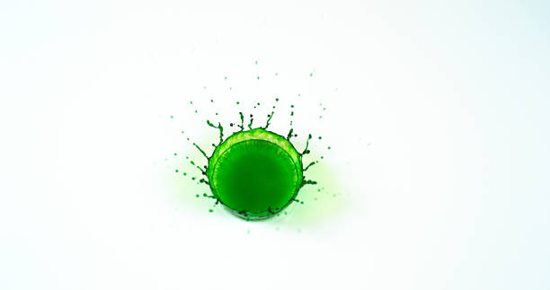 istock Green Liquid falling into Water against White Background 1727611780