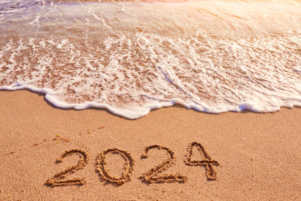 istock 2024 year written on sandy beach sea at sunny day 1727619058