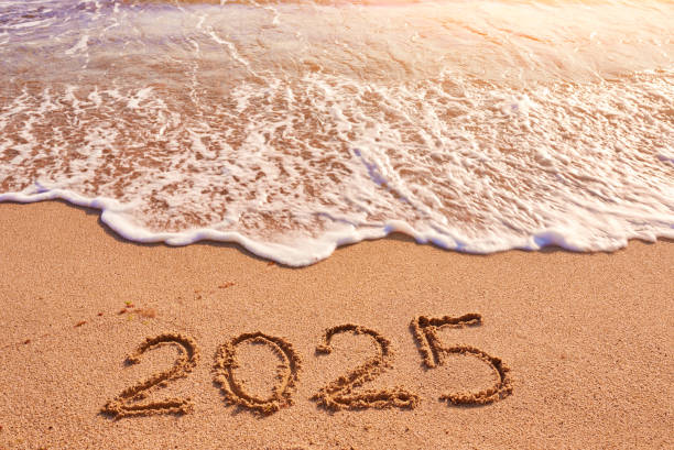 istock 2025 year written on sandy beach sea at sunny day 1727619066