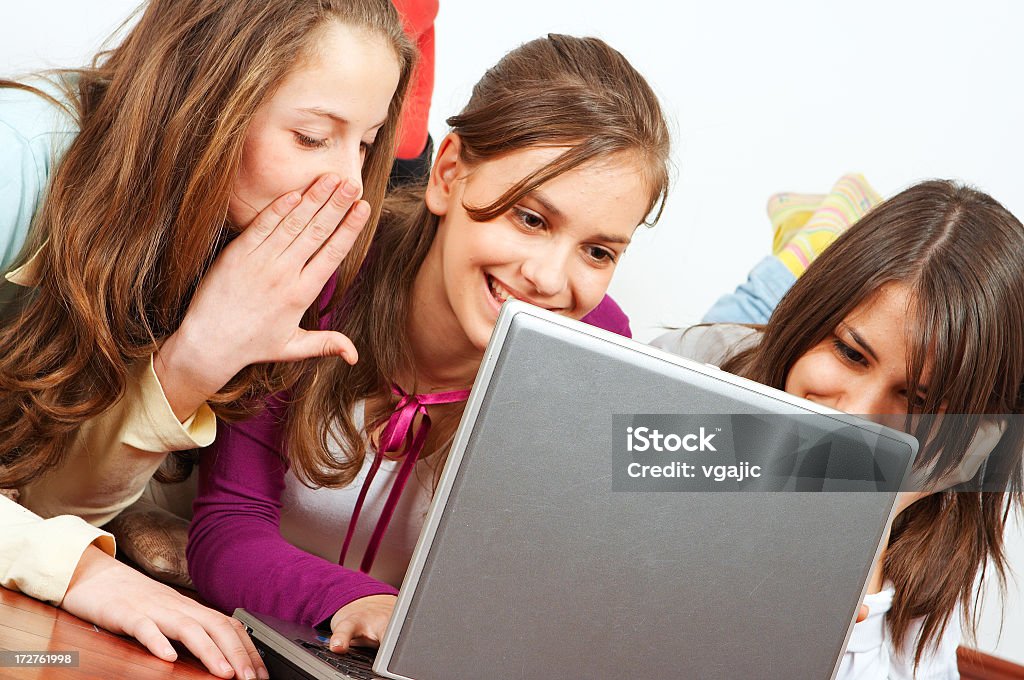 Girls with laptop Closeup of young teenager girls having fun with internet on laptop Adolescence Stock Photo