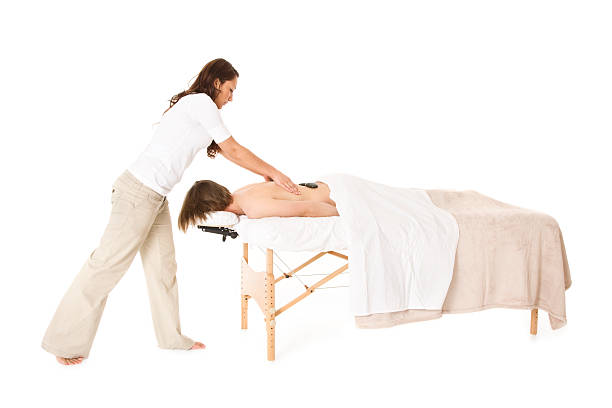 massagem de pedras quentes - massage table imagens e fotografias de stock