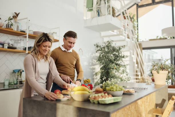istock Happy couple preparing food in the kitchen. 1727621759