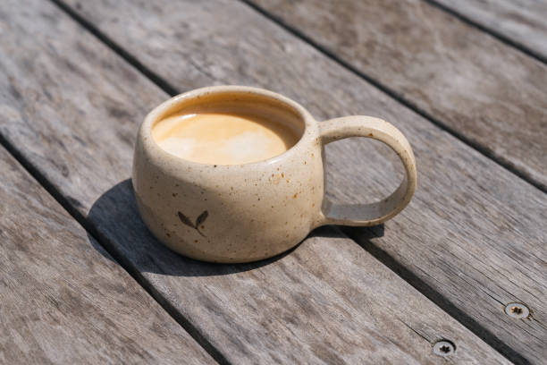 istock Close-Up Clay Coffee Cup with Coffee on Wooden Table 1727623191