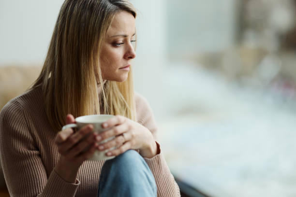 istock Worried woman during coffee time by the window. 1727630126
