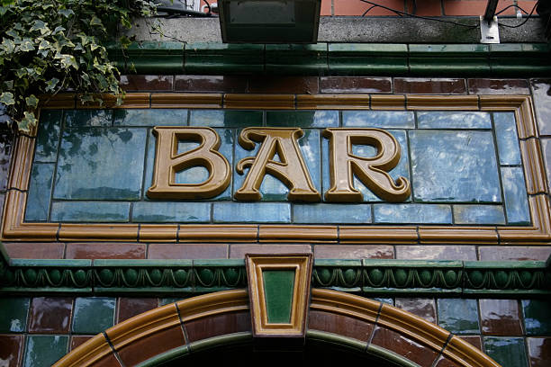 Pub Fascia Lettering Glazed tile, three-dimensional lettering of the word 'Bar', in antique Art Nouveau style on the exterior fascia of a British Pub pub stock pictures, royalty-free photos & images