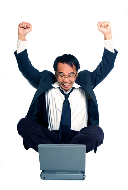 Businessman celebrating success with a laptop "Portrait of a successful businessman with raised arms in front of a laptop, isolated on white." stars in your eyes stock pictures, royalty-free photos & images