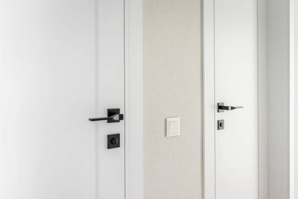 istock Modern black door handle on white wooden door in interior. Knob close-up elements 1727641639