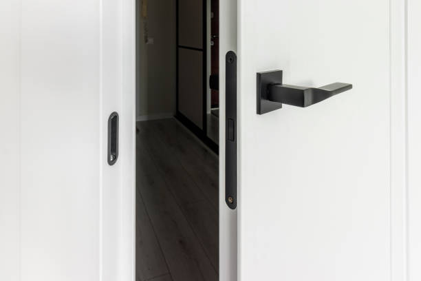 istock Modern black door handle on white wooden door in interior. Knob close-up elements 1727641649