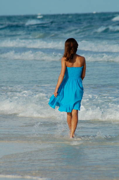 "Mulher caminhando ao longo da praia" - foto de acervo