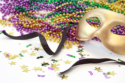 Gold Carnival mask with beads in Mardi Gras colors isolated on white