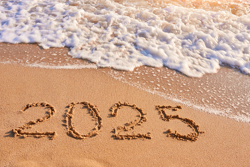 2025 year drawing on sandy beach sea at sunny day