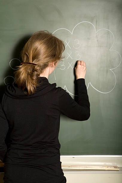 istock Teacher writes sums on the blackboard 172766051