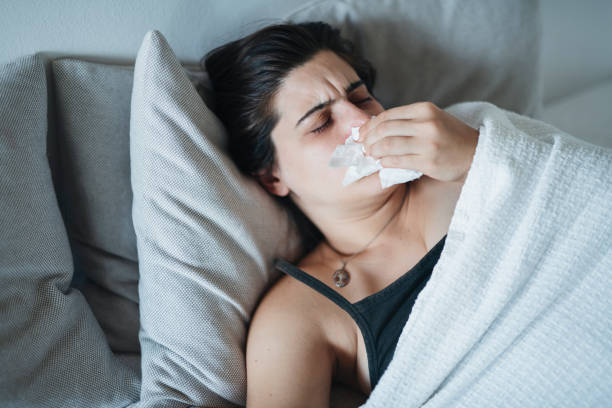 istock Woman having a cold and laying in bed. 1727661884