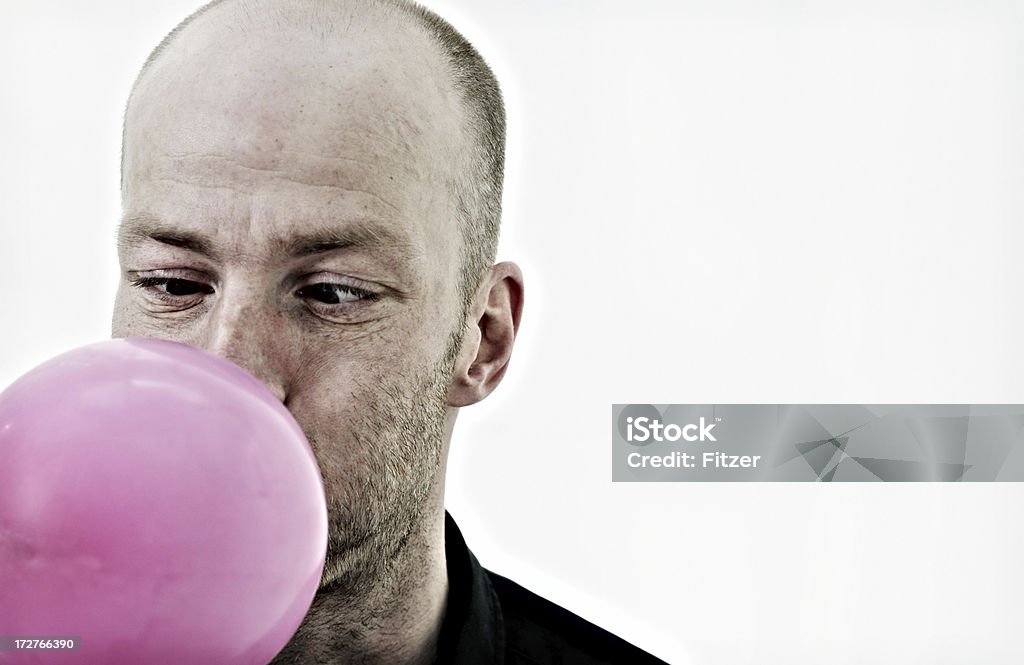 man blowing a pink balloon man blowing a balloon... Balloon Stock Photo