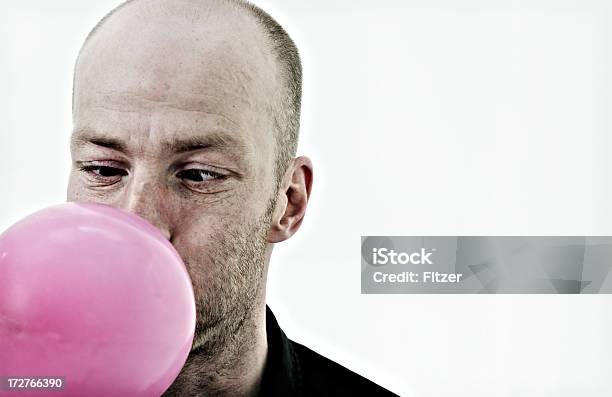 Man Blowing A Pink Balloon Stock Photo - Download Image Now - Balloon, Blowing, Men