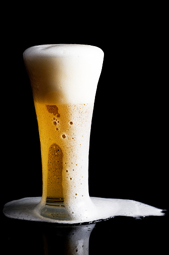 Glass of beer on black background