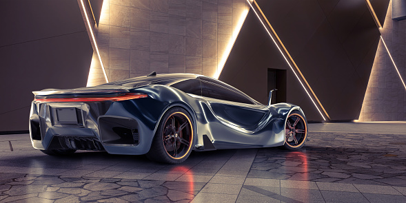 Rear view of a generic electric sports car with orange lights in the wheels parked in an architectural interior with embedded lights in the wall on tiled surface.