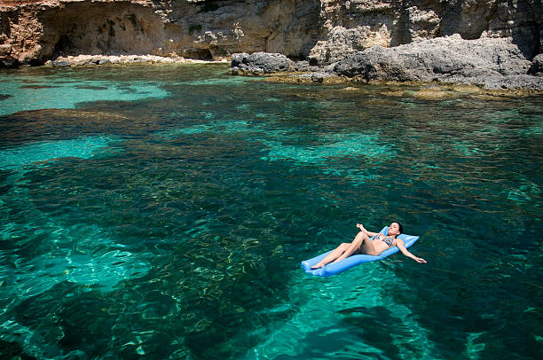 jeune femme allongée sur un matelas pneumatique, vacances méditerranéennes - floating on water water women wet photos et images de collection