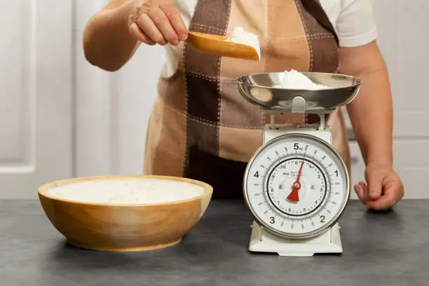 Senior woman weighing flour