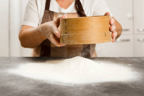 istock Elderly woman sifting flour 1727688757