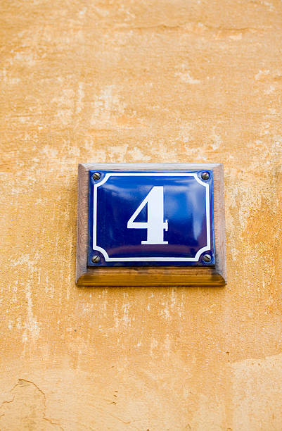 istock House number 4. Blue enamel sign on yellow wall. 172769000