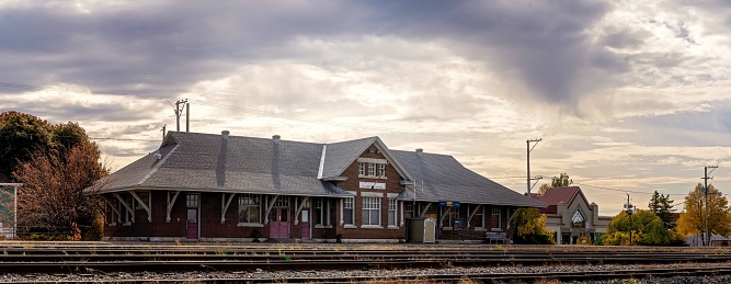 A picturesque railway station illuminated by the warm, orange light of the setting sun