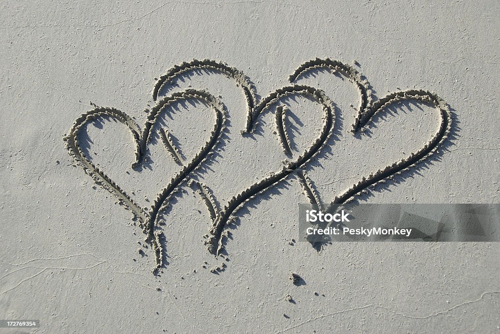 Tre cuori disegnati in morbida grigio sabbia - Foto stock royalty-free di Poligamia