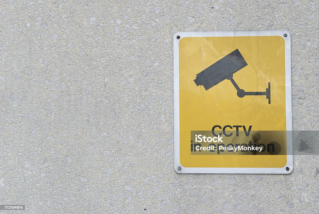 Giallo simbolo di CCTV con icona della telecamera di sicurezza sulla Parete di cemento - Foto stock royalty-free di Composizione orizzontale