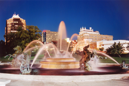 Small round fountain with blue water isolated on white