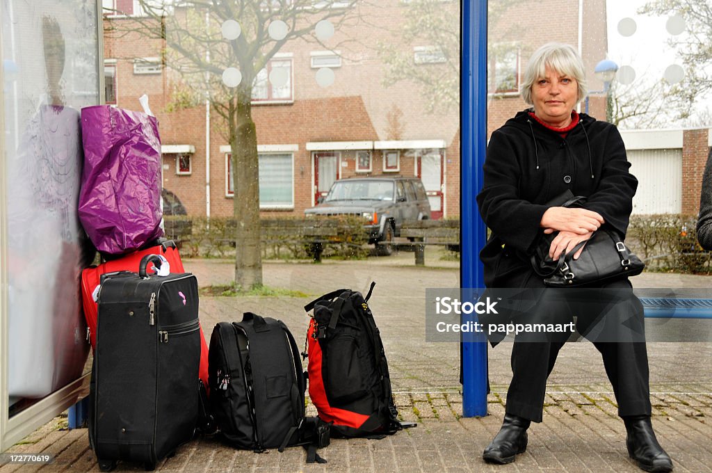 Sênior mulher com bagagem no busshelter - Foto de stock de Ponto de ônibus royalty-free