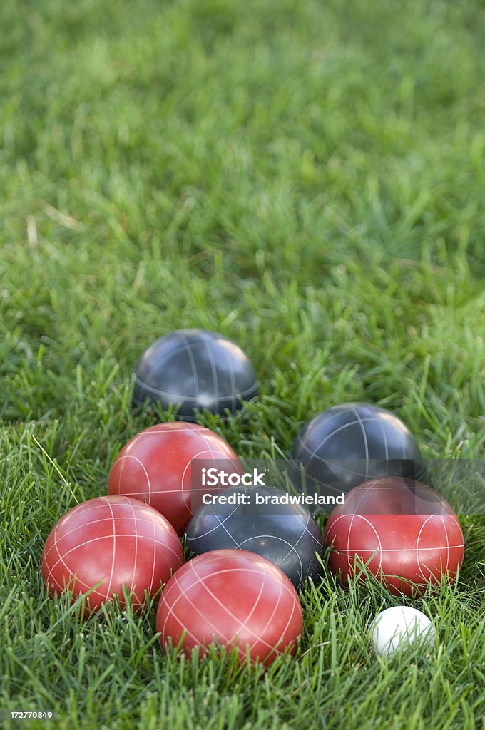 Bocce Ball Black and red bocce balls nestled in lush green grass. Activity Stock Photo