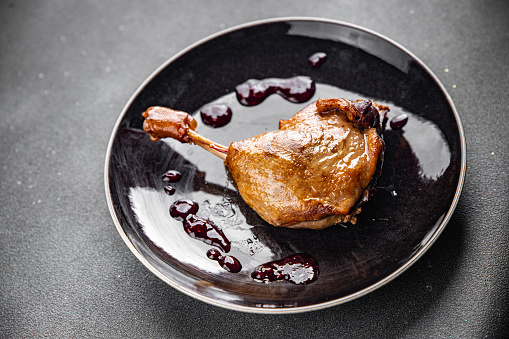 duck leg confit with berry sauce poultry meat second course vegetable delicious healthy eating cooking appetizer meal food snack on the table copy space food background rustic top view