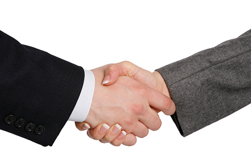 Close up panoramic shot of two businessmen shaking hands.