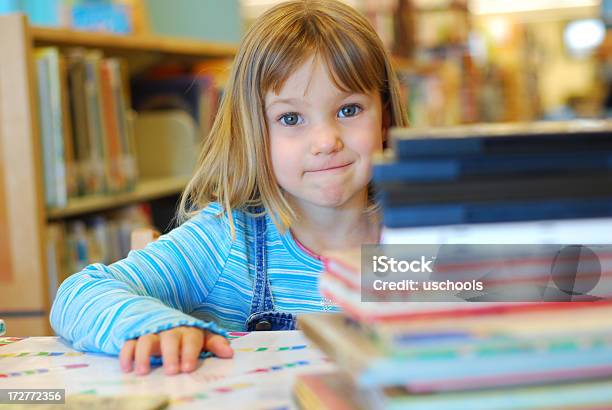 Kleines Mädchen Mit Stapel Von Büchern In Der Bibliothek Stockfoto und mehr Bilder von Bibliothek