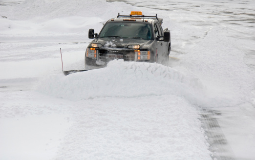 A snow plow cleans up a parking lot after a storm.You might also like...