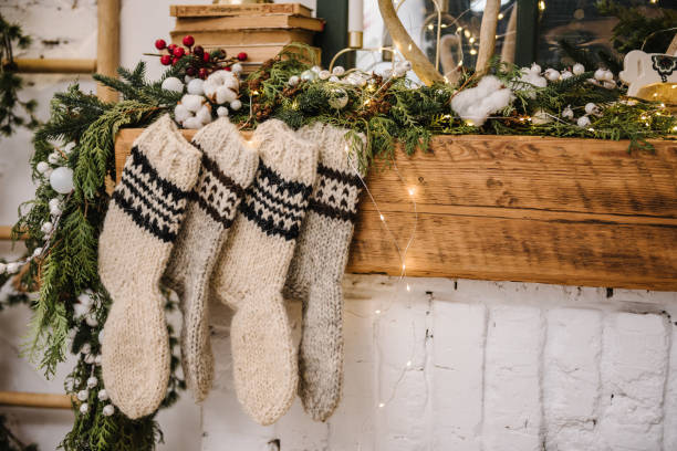 Christmas knitted woolen socks closeup. Decorative fireplace with Christmas stockings, garlands and gifts in stylish room interior. Happy New Year and Merry Christmas. Christmas knitted woolen socks closeup. Decorative fireplace with Christmas stockings, garlands and gifts in stylish room interior. Happy New Year and Merry Christmas. christmas stocking stock pictures, royalty-free photos & images